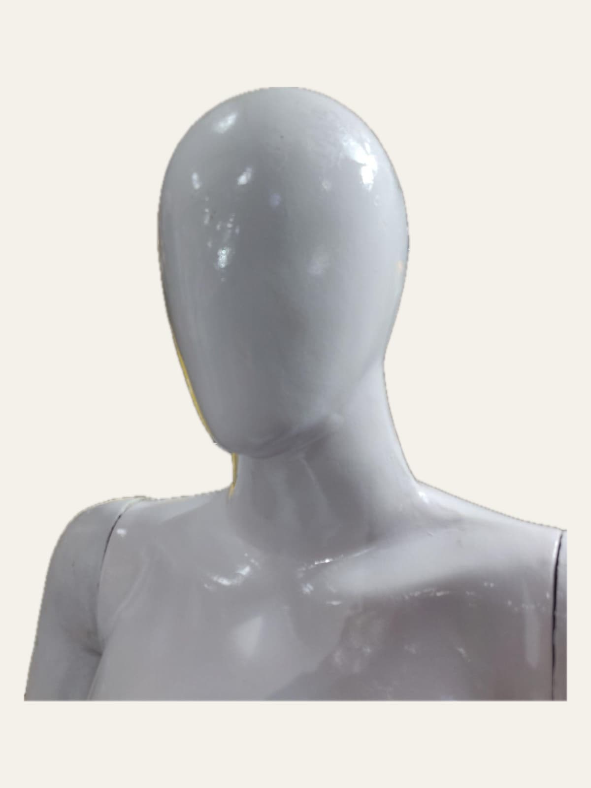 Close view of a white female mannequin's featureless head and shoulders
